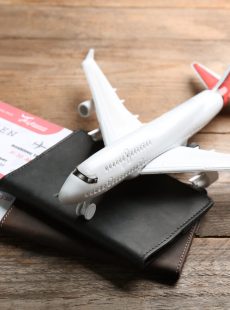 Toy,Airplane,And,Passports,With,Tickets,On,Wooden,Background